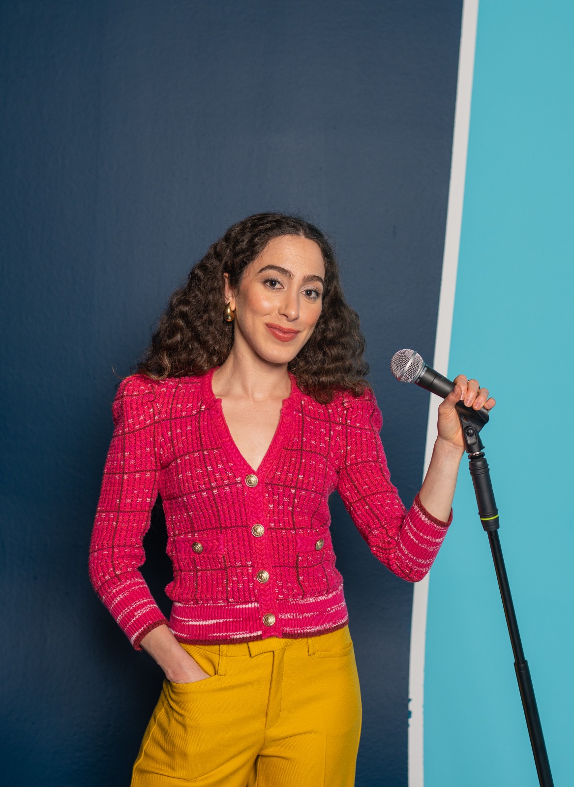 A ToPS speaker holding a microphone, mid-moment, in the brand color palette